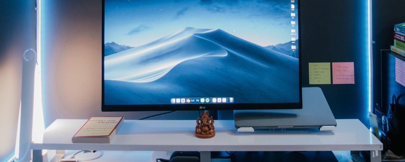 Computer monitor and keyboard on a desk representing digital creation for NFTs