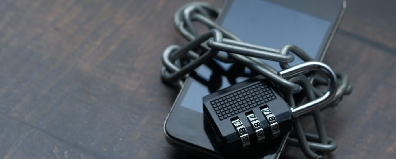 Smartphone secured with a chain and padlock symbolizing how to protect your crypto seed phrase