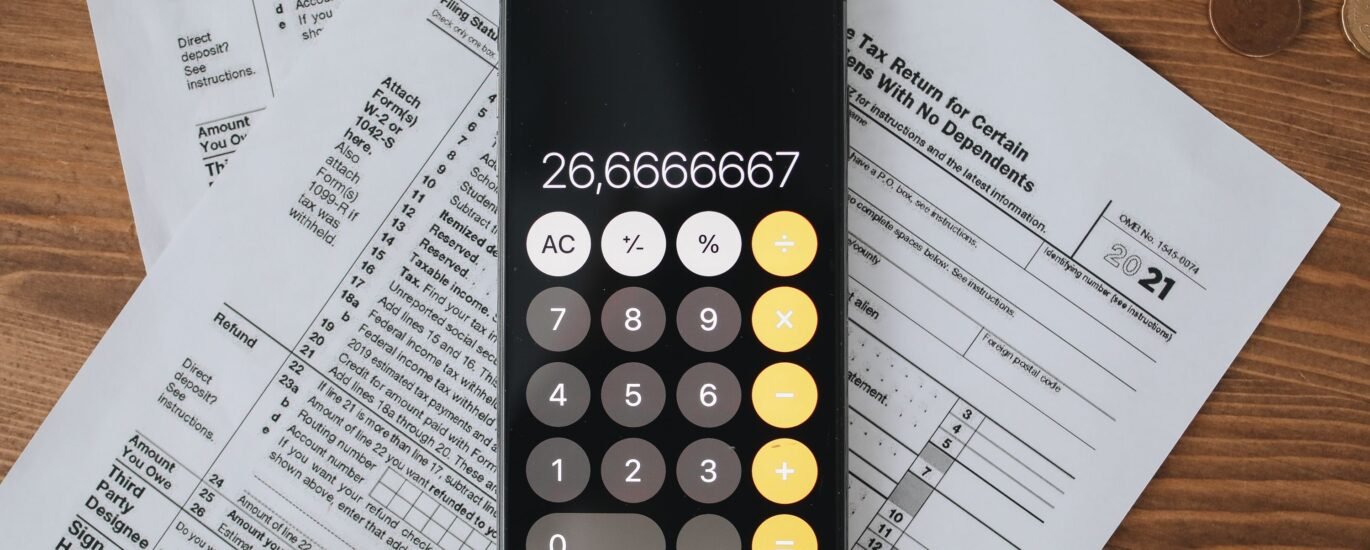 Tax documents and calculator representing how crypto is taxed in the UK