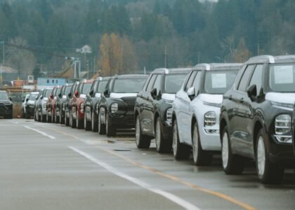Row of new cars in a dealership lot representing buying a car with crypto