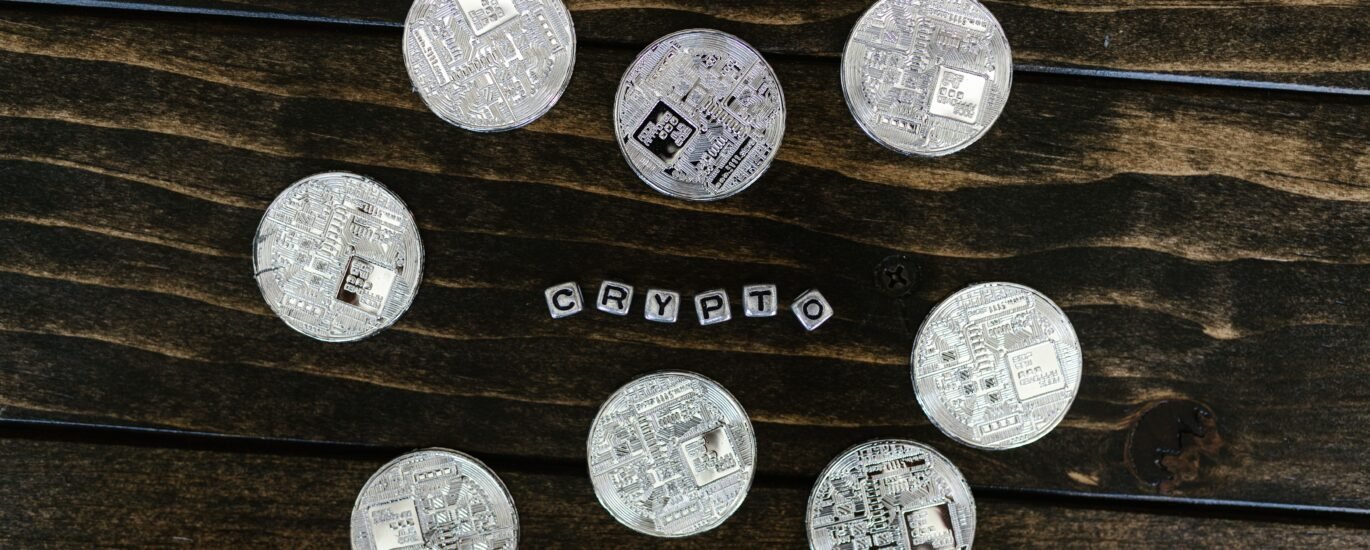 Silver cryptocurrency coins on a wooden surface representing Litecoin and crypto investing in the UK
