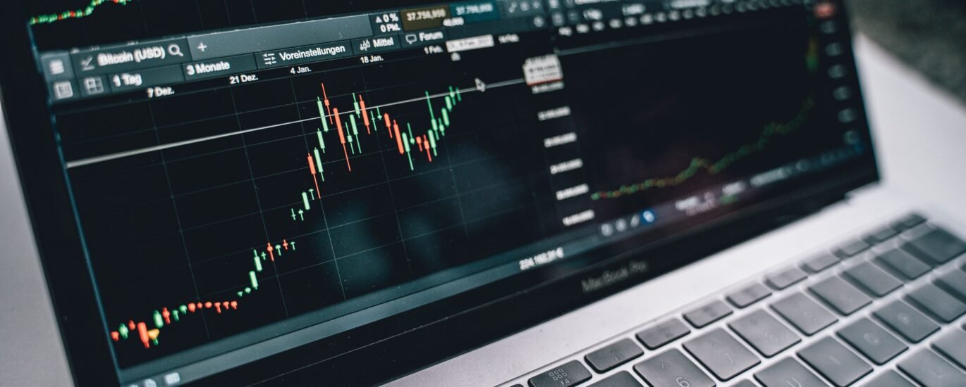 Laptop displaying a stock market trading chart