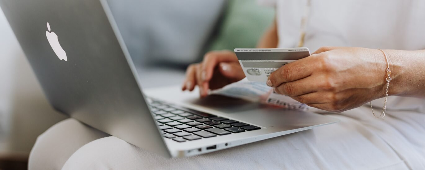 Person holding credit card while shopping online, representing spending Solana on gift cards