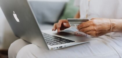 Person holding credit card while shopping online, representing spending Solana on gift cards