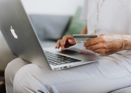 Person holding credit card while shopping online, representing spending Solana on gift cards